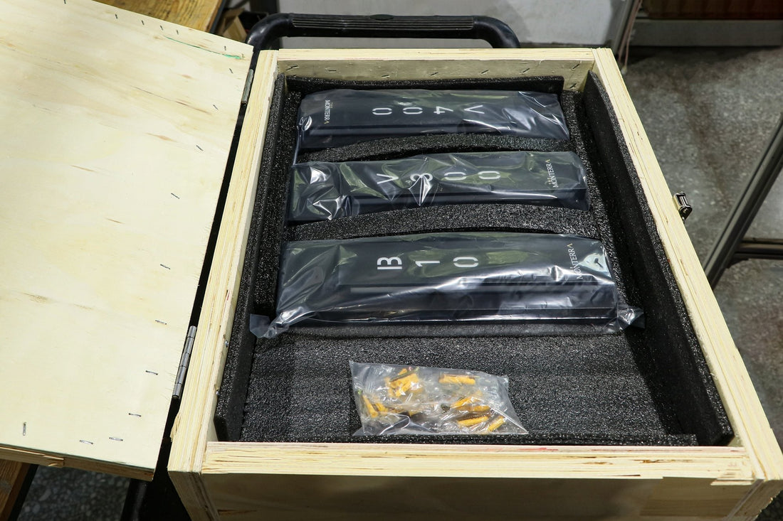 Hotel room number signs organized in a foam-lined wooden crate