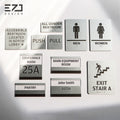 Silver-painted acrylic tactile and Braille sign family with restroom, room ID, facility, and exit signs