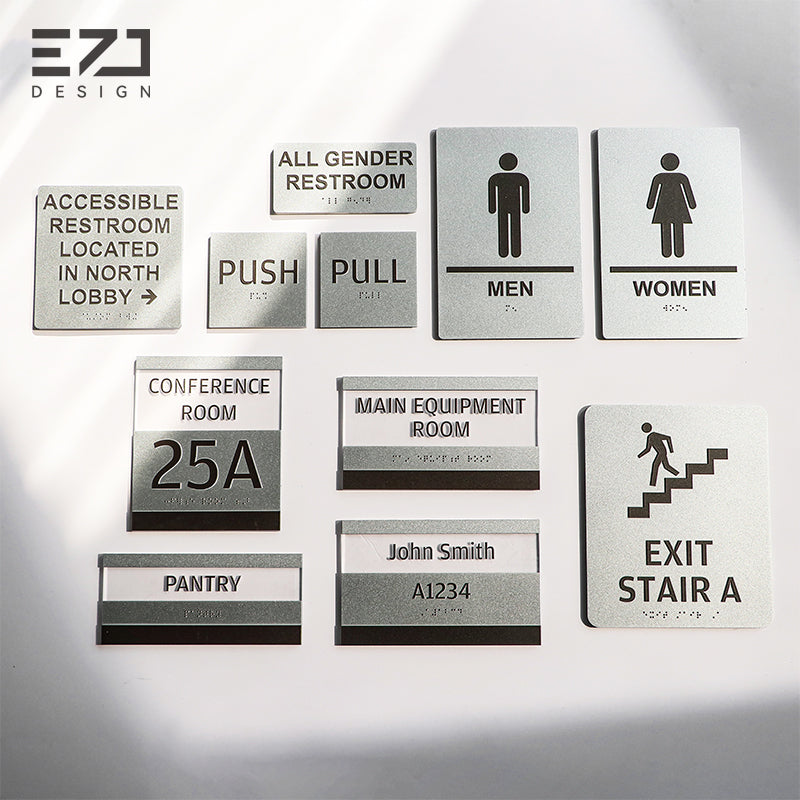 Silver-painted acrylic tactile and Braille sign family with restroom, room ID, facility, and exit signs