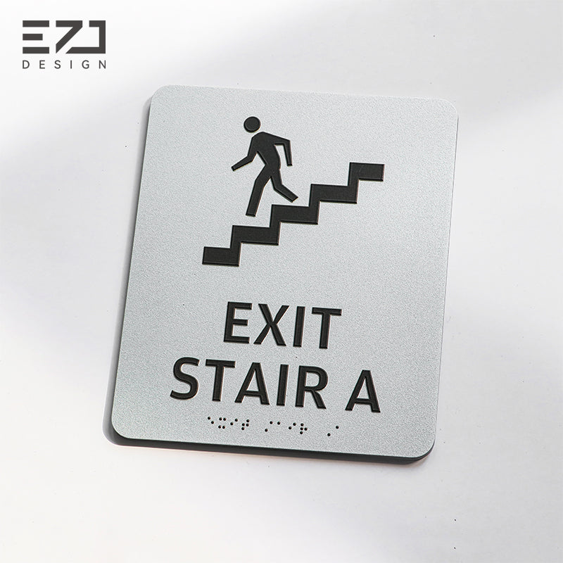 Silver-painted acrylic tactile exit stair sign with raised icon and Braille