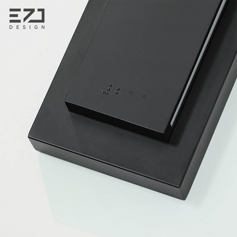UV-raised braille detail on a matte-black room number sign