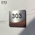 Wood-grain stainless steel hotel room number sign with braille